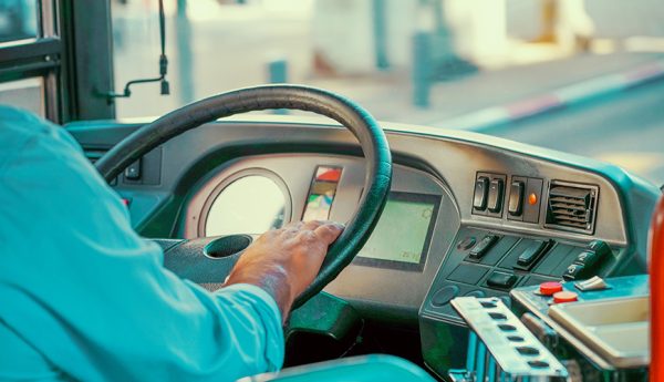 Bus driver holding steering whee